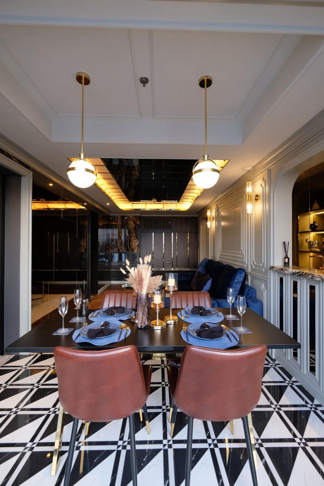 Dining room with elegant table setting, luxurious chairs, and contemporary lighting.