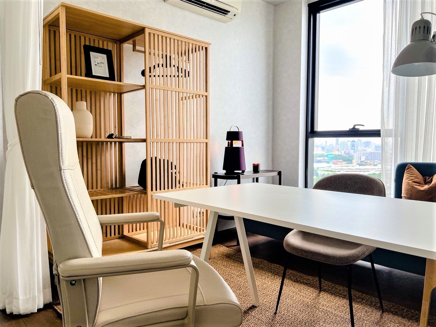 Office space with wood shelving, ergonomic chair, and large window.