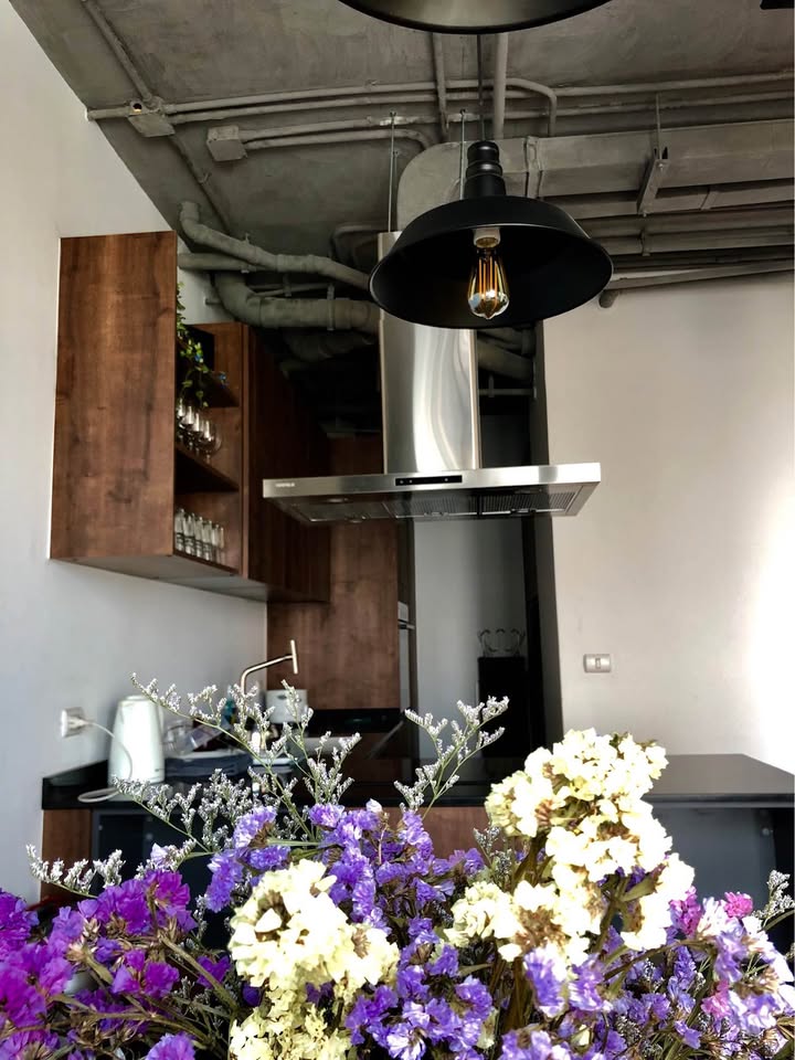 Spacious loft-style 1-bedroom duplex at Villa Asoke with high ceilings, floor-to-ceiling windows, modern furnishings, and city skyline views in Bangkok.