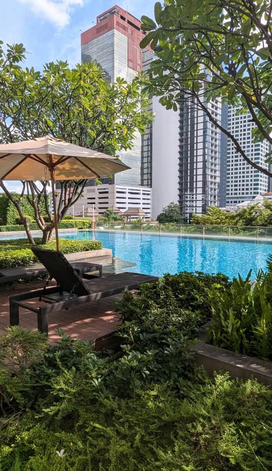 Spacious loft-style 1-bedroom duplex at Villa Asoke with high ceilings, floor-to-ceiling windows, modern furnishings, and city skyline views in Bangkok.