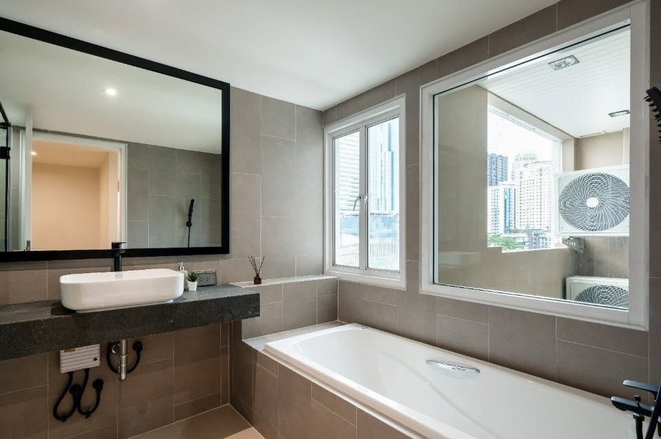 Top-floor corner unit at Le Nice Ekamai featuring a spacious 3-bedroom layout, modern western kitchen with island, and panoramic city views.