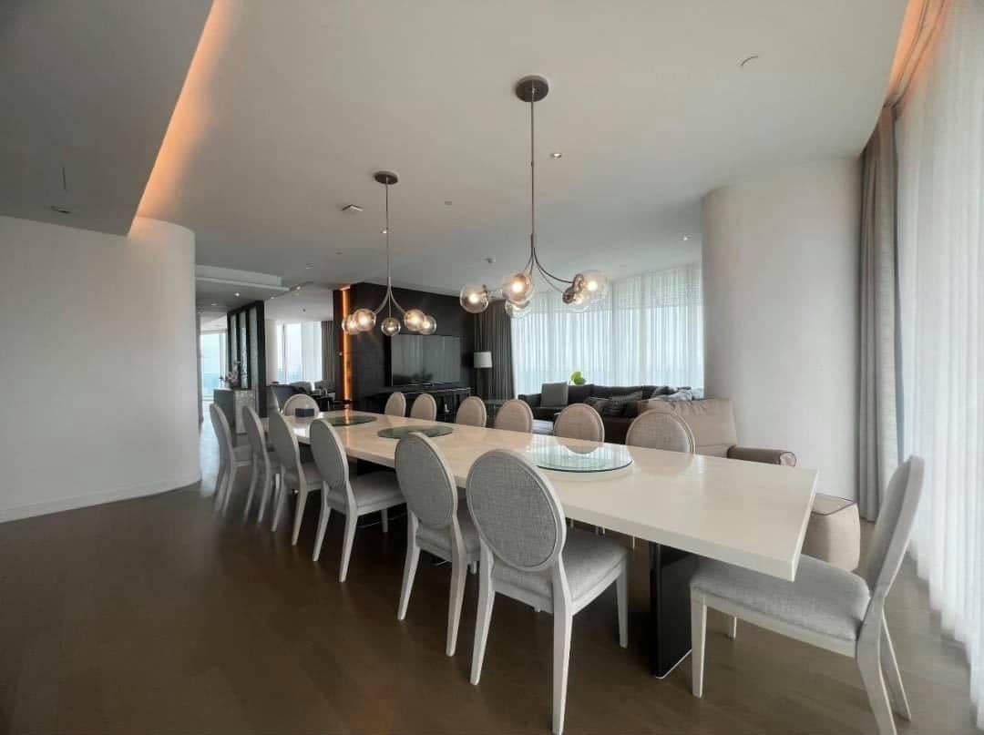 Spacious living room with floor-to-ceiling windows and panoramic city views in a luxury 4-bedroom condo at Magnolias Ratchadamri Boulevard, Bangkok.
