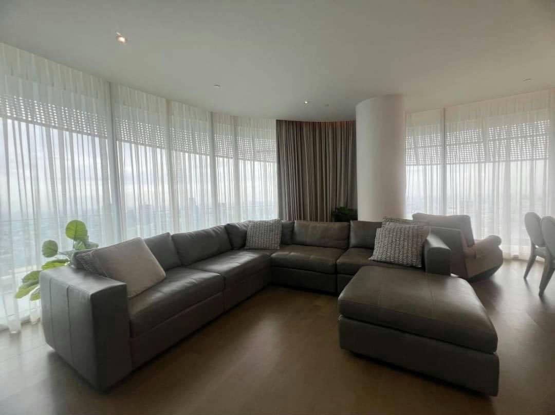 Spacious living room with floor-to-ceiling windows and panoramic city views in a luxury 4-bedroom condo at Magnolias Ratchadamri Boulevard, Bangkok.