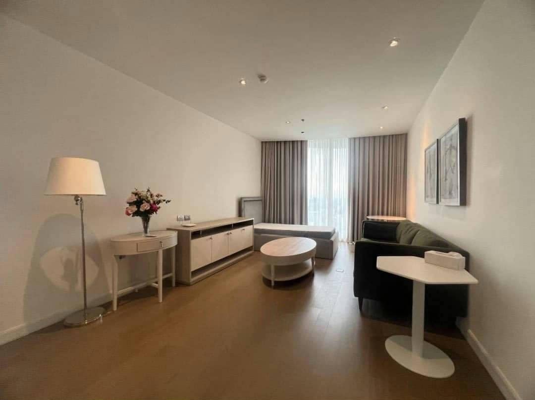 Spacious living room with floor-to-ceiling windows and panoramic city views in a luxury 4-bedroom condo at Magnolias Ratchadamri Boulevard, Bangkok.