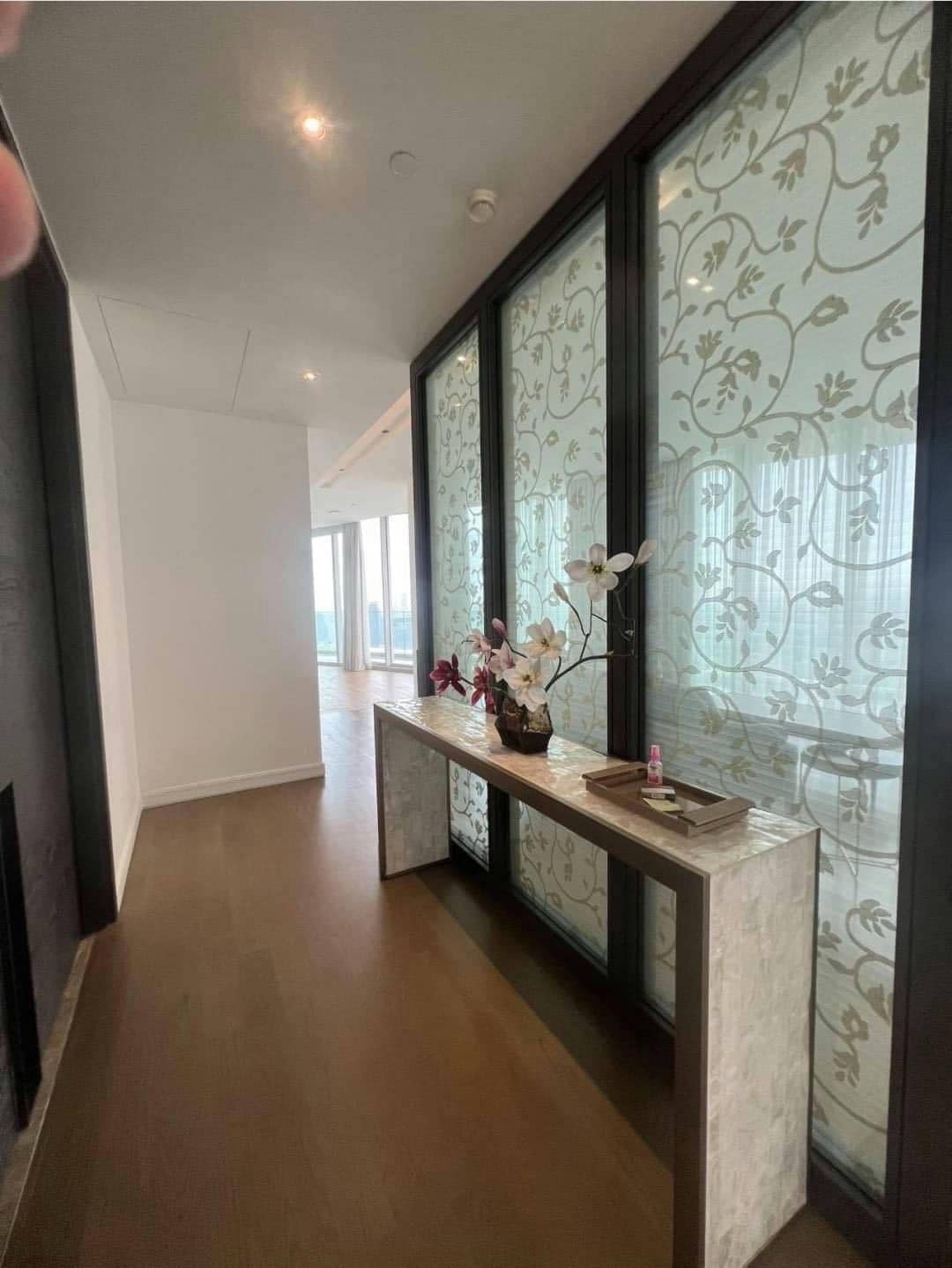 Spacious living room with floor-to-ceiling windows and panoramic city views in a luxury 4-bedroom condo at Magnolias Ratchadamri Boulevard, Bangkok.