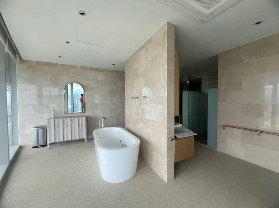 Spacious living room with floor-to-ceiling windows and panoramic city views in a luxury 4-bedroom condo at Magnolias Ratchadamri Boulevard, Bangkok.