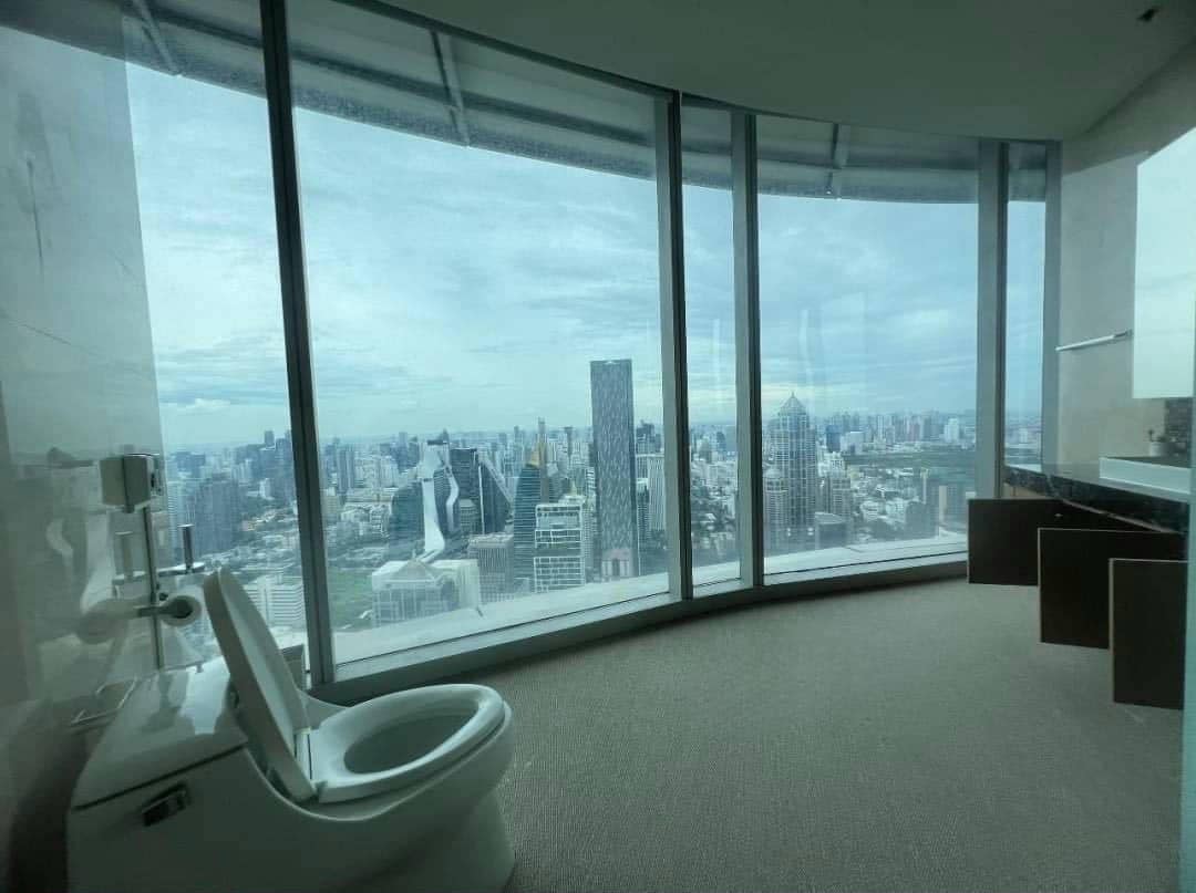 Spacious living room with floor-to-ceiling windows and panoramic city views in a luxury 4-bedroom condo at Magnolias Ratchadamri Boulevard, Bangkok.