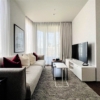 Elegant living room with sofa, pillows, and large windows showcasing a city view.