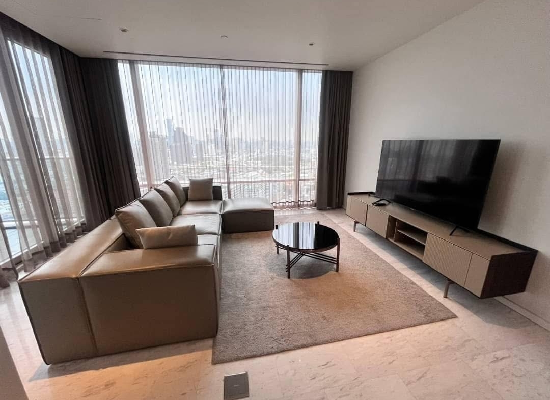 Spacious and modern living room in a 2-bedroom condo at Four Seasons Private Residences, featuring floor-to-ceiling windows and breathtaking views of the Chao Phraya River.