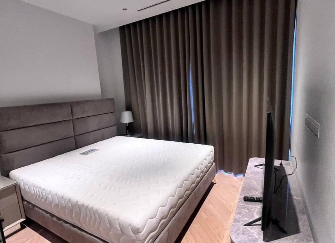 Spacious and modern living room in a 2-bedroom condo at Four Seasons Private Residences, featuring floor-to-ceiling windows and breathtaking views of the Chao Phraya River.