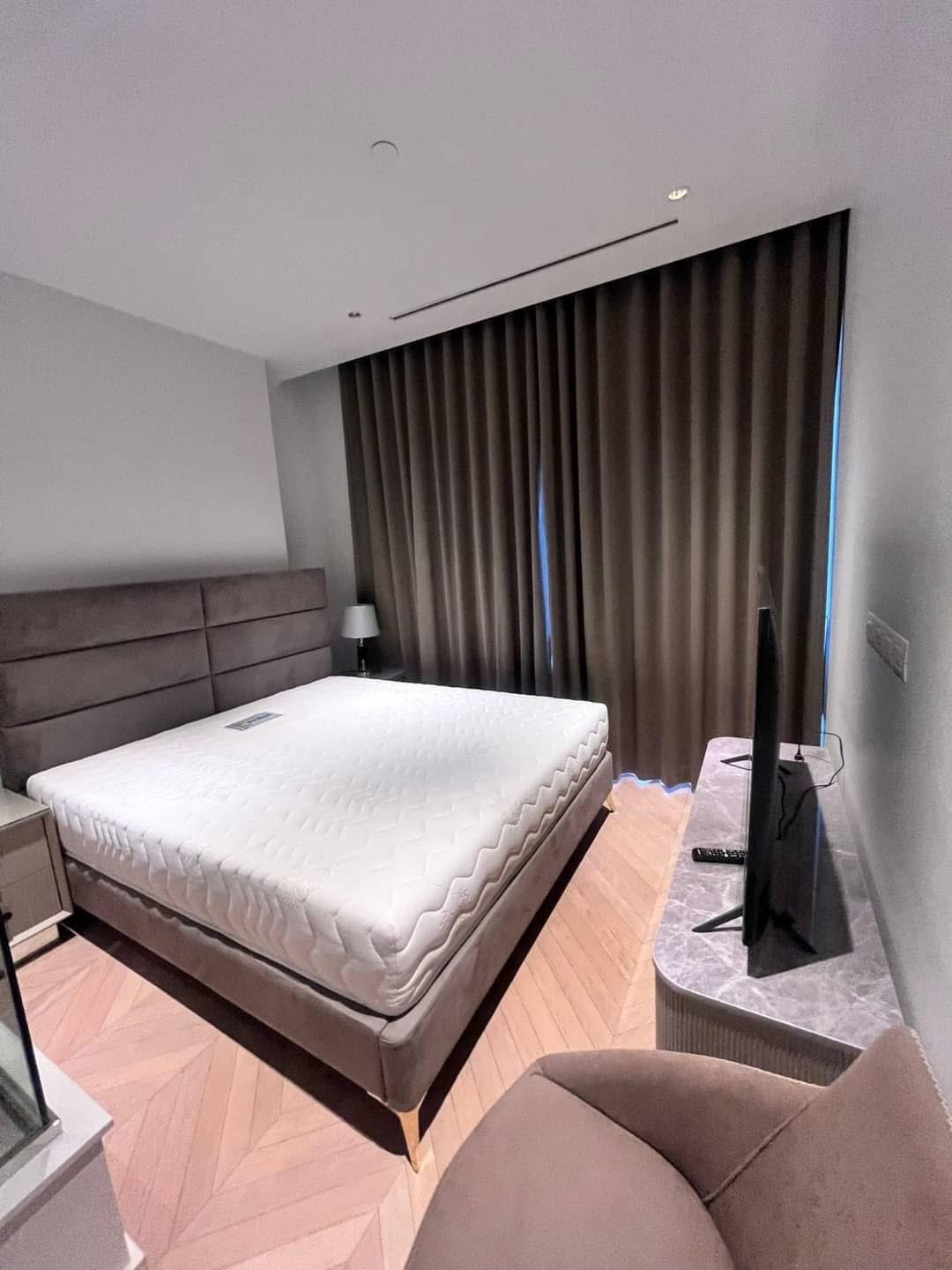 Spacious and modern living room in a 2-bedroom condo at Four Seasons Private Residences, featuring floor-to-ceiling windows and breathtaking views of the Chao Phraya River.