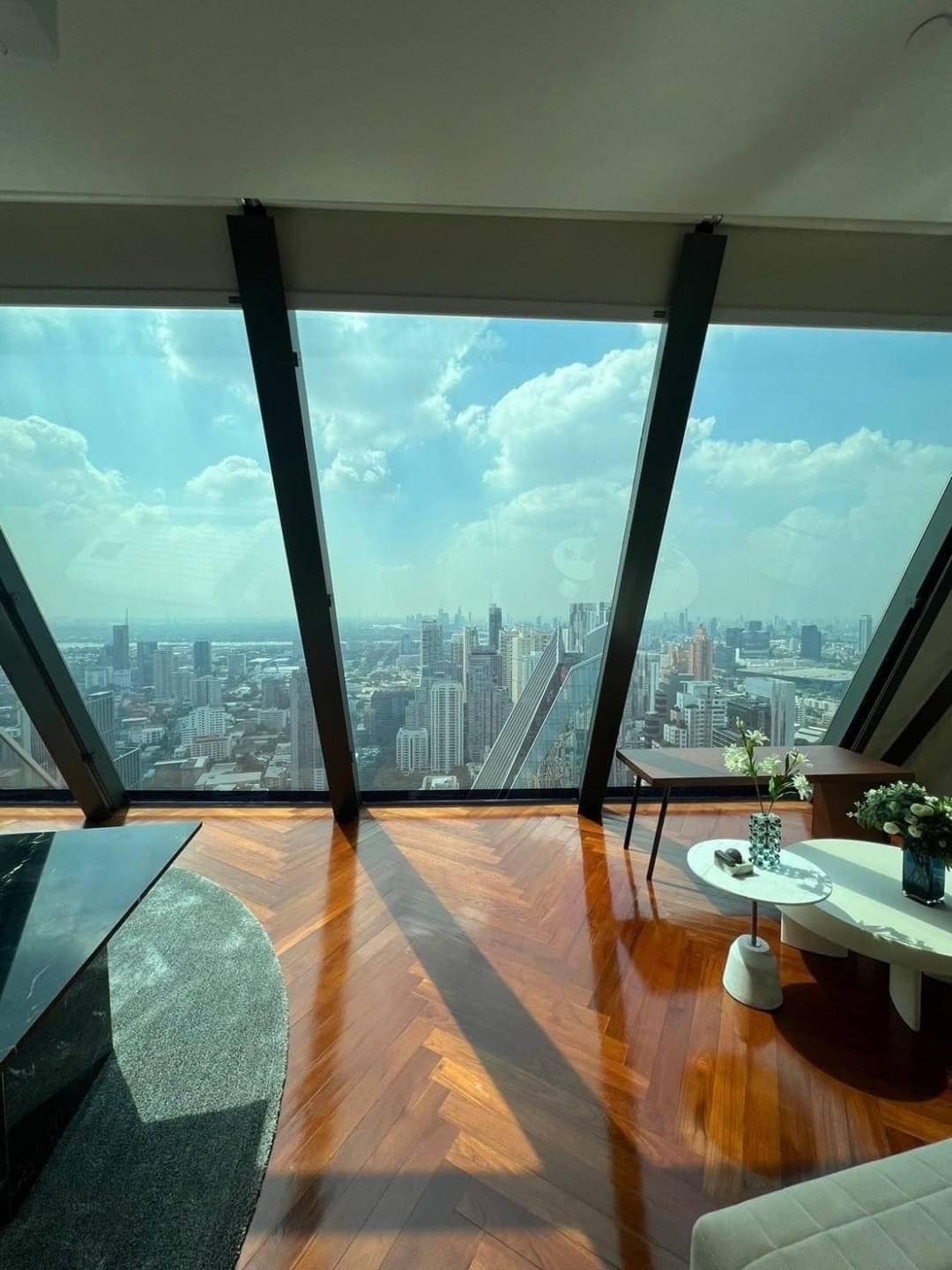 Spacious living room with floor-to-ceiling windows and panoramic city views in a luxury 3-bedroom condo at Marque Sukhumvit 39, Bangkok.