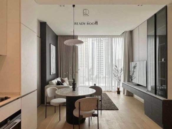 Spacious and modern living room in a 1-bedroom condo at The Strand Thonglor, featuring floor-to-ceiling windows and elegant furniture near BTS Thonglor, Bangkok.
