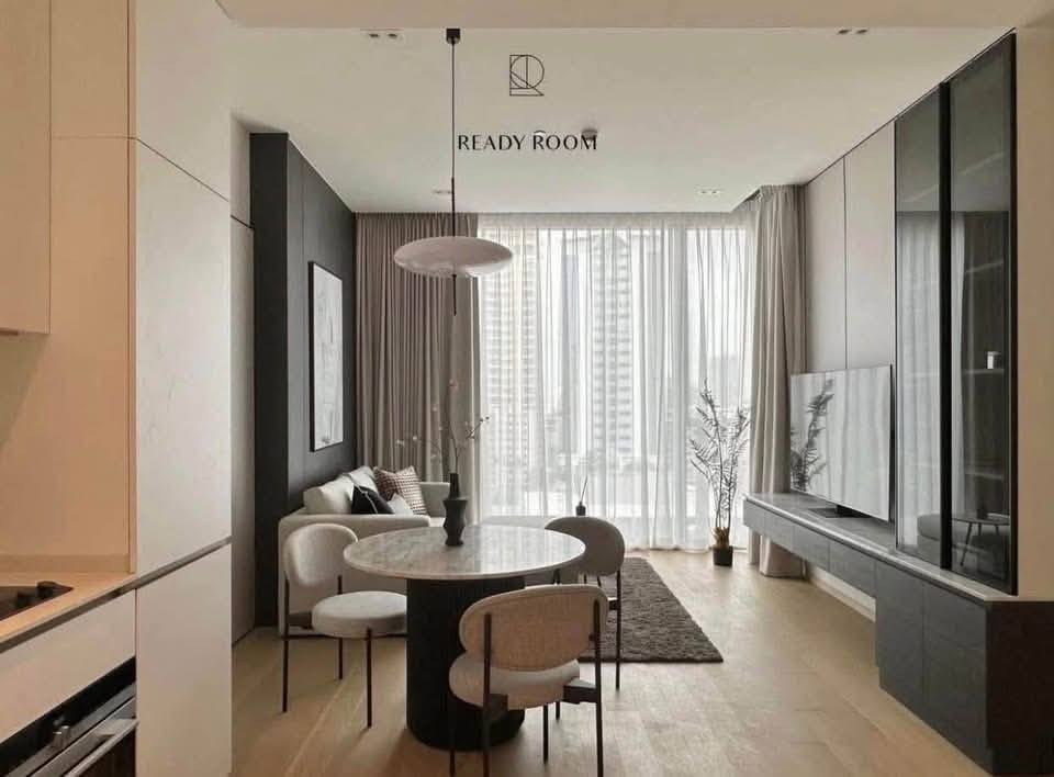 Spacious and modern living room in a 1-bedroom condo at The Strand Thonglor, featuring floor-to-ceiling windows and elegant furniture near BTS Thonglor, Bangkok.