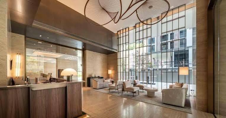 Spacious and modern living room in a 1-bedroom condo at The Strand Thonglor, featuring floor-to-ceiling windows and elegant furniture near BTS Thonglor, Bangkok.