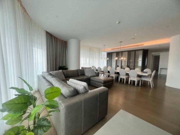 Spacious living room with floor-to-ceiling windows and panoramic city views in a luxury 4-bedroom condo at Magnolias Ratchadamri Boulevard, Bangkok.