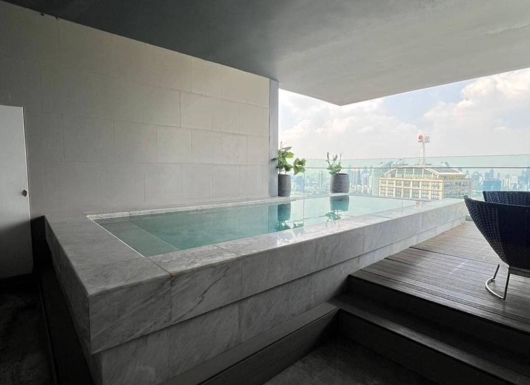 Spacious living room with floor-to-ceiling windows and panoramic city views in a luxury 3-bedroom condo at Marque Sukhumvit 39, Bangkok.