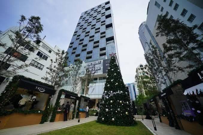 Spacious and modern living room in a 1-bedroom condo at The Strand Thonglor, featuring floor-to-ceiling windows and elegant furniture near BTS Thonglor, Bangkok.