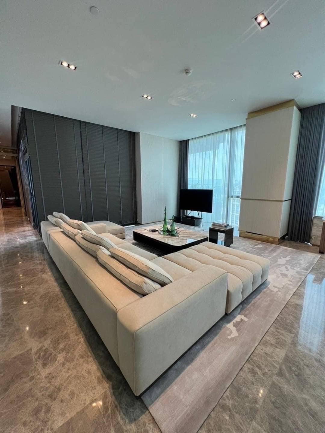 Spacious living room with floor-to-ceiling windows and panoramic city views in a luxury 3-bedroom condo at Marque Sukhumvit 39, Bangkok.