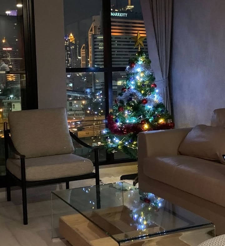 Elegant living room of 2-bedroom condo at Noble Ploenchit with city view and modern furnishings