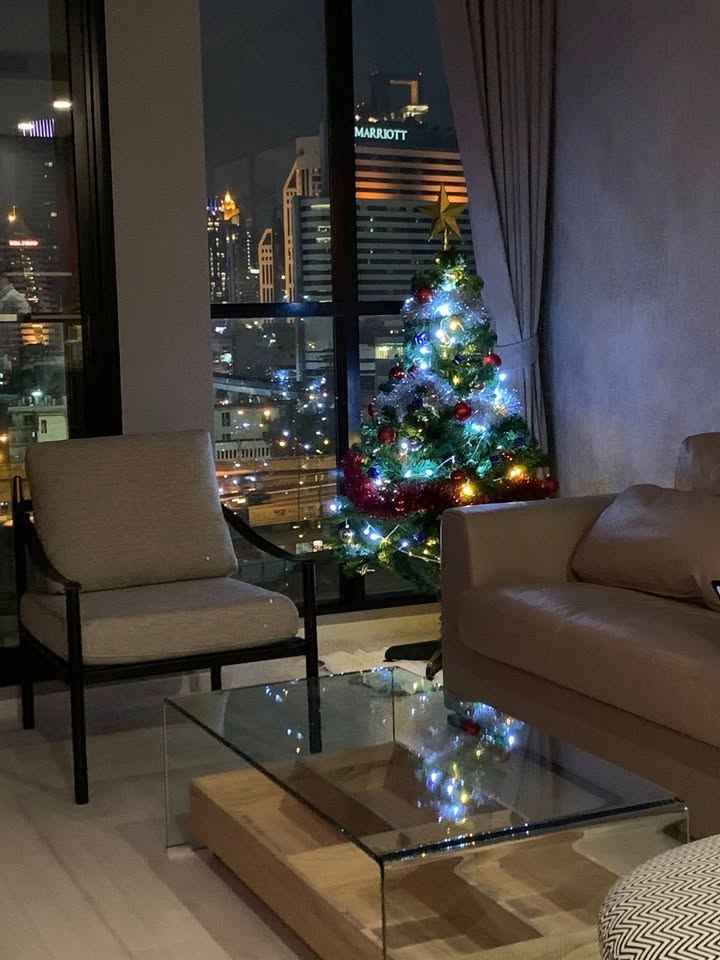 Elegant living room of 2-bedroom condo at Noble Ploenchit with city view and modern furnishings