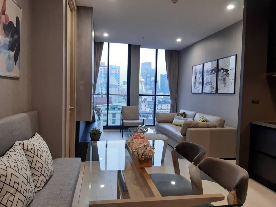 Elegant living room of 2-bedroom condo at Noble Ploenchit with city view and modern furnishings