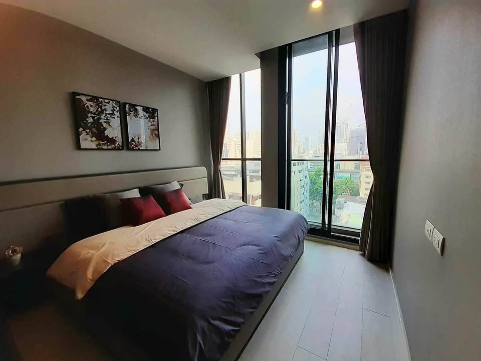 Elegant living room of 2-bedroom condo at Noble Ploenchit with city view and modern furnishings
