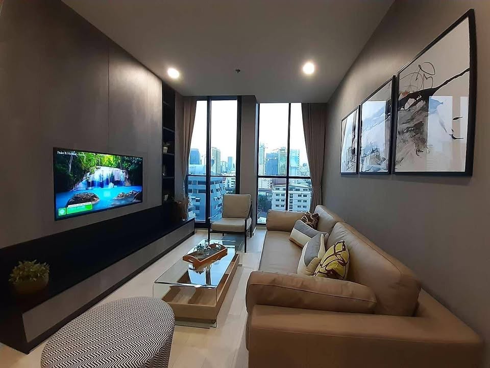 Elegant living room of 2-bedroom condo at Noble Ploenchit with city view and modern furnishings
